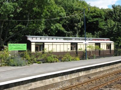 camping coach behind a station platform