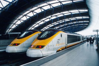 Two Eurostar trains in a station with an elaborate curving roof