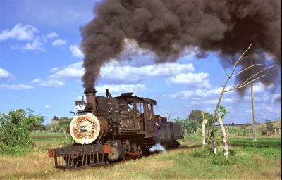 A typical scene on a Cuban sugar plantation railway. – Jim Ballantyne A well-used American narrow gauge steam locomotive belches black smoke on a Cuban sugar plantation railway.