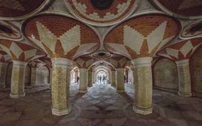 Elaborate underground pillared structure with a vaulted ceiling of red and cream bricks, and a  decorative stone tiled floor
