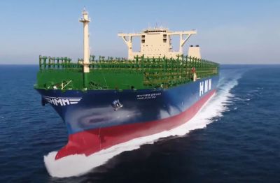 One of the world's largest container ships, HMM Algeciras, seen during sea trials off the coast of South Korea in 2020. – (Photo: HMM) A very large, but empty, container ship proceeding at speed in the middle of an almost calm, deep blue sea.