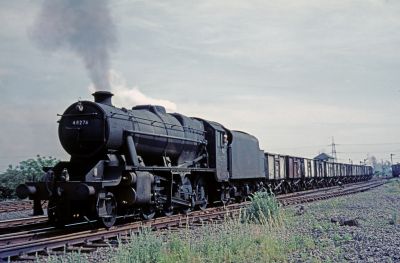 48276, ex-LMS Stanier 8F 2-8-0, heads an unfitted coal train through Royston on 9th July 1966 (Trevor Polding, courtesy of Huddersfield Railway Circle.) A slightly run-down 2-8-0 steam locomotive at the head of a train of short wheelbase, steel coal wagons, in a goods yard surrounded by flat countryside.
