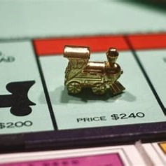 Train game piece on a Monopoly board Train game piece on a Monopoly board