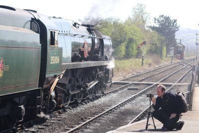 SWRS Vice-Chairman Matt Francis photographing his favourite, rebuilt Merchant Navy Bulleid Pacific no. 35006 'Peninsular & Oriental S. N. Co.', at Toddington on the Gloucestershire Warwickshire Steam Railway, 5th April 2025. Image Credit: James Taviner An enthusiast taking a photo of a large steam locomotive at a heritage railway station.