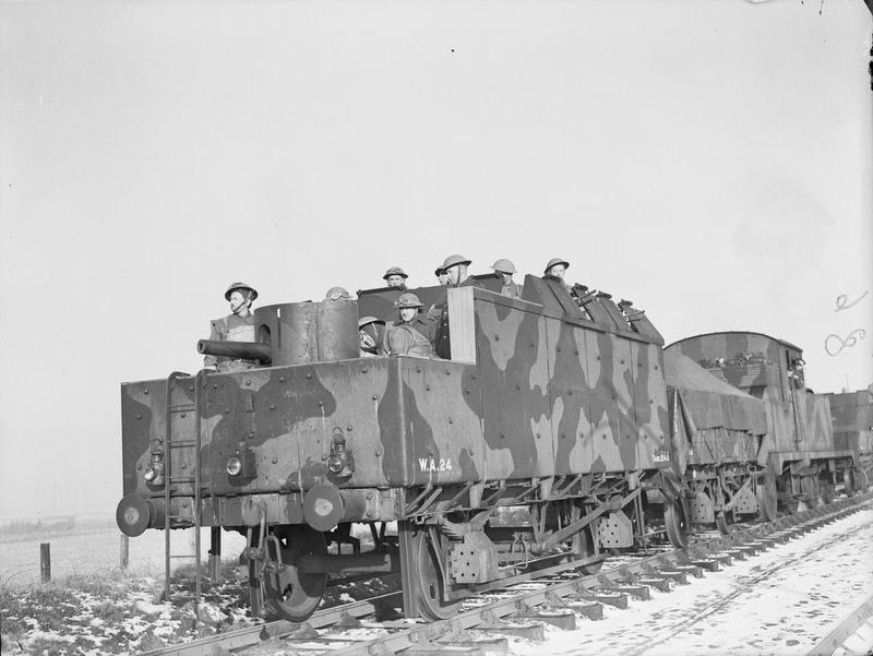 A British armoured train in Scotland during World War Two. The small steam locomotive is in the middle of the train, between two short goods wagons for carrying ammunition. At each end, and the feature of the photo, is an armoured open wagon with a turret for a Bren gun, plus several machine gun emplacements, either side. A company of soldiers can be seen in tin hats at their allotted stations.